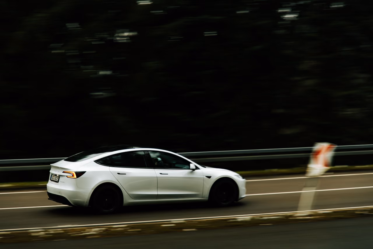 A modern electric car in motion on a highway, showcasing speed and innovation.